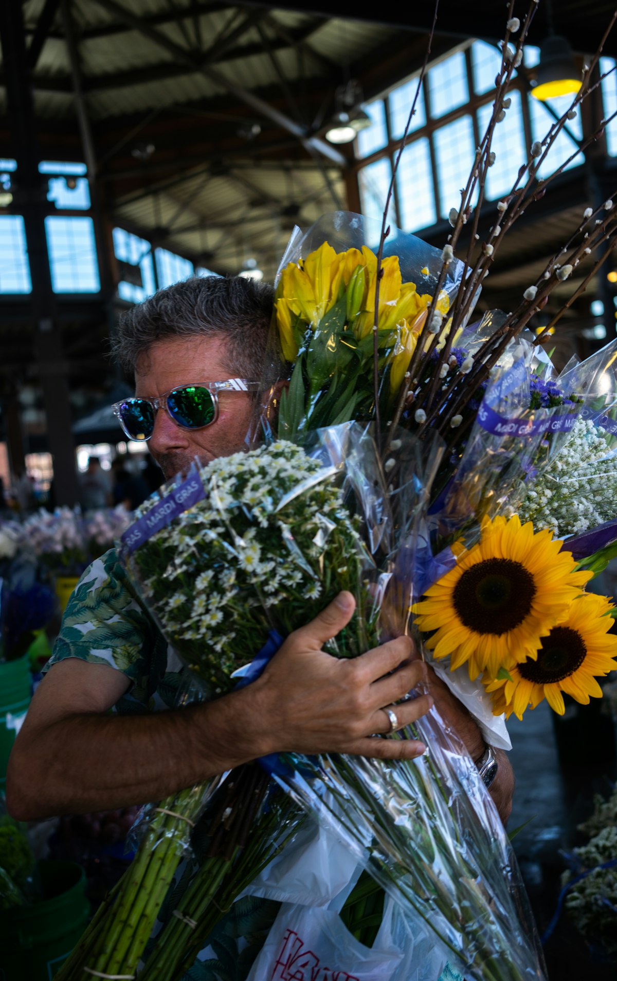 Vendor holding armfuls of sunflowers and bouquets