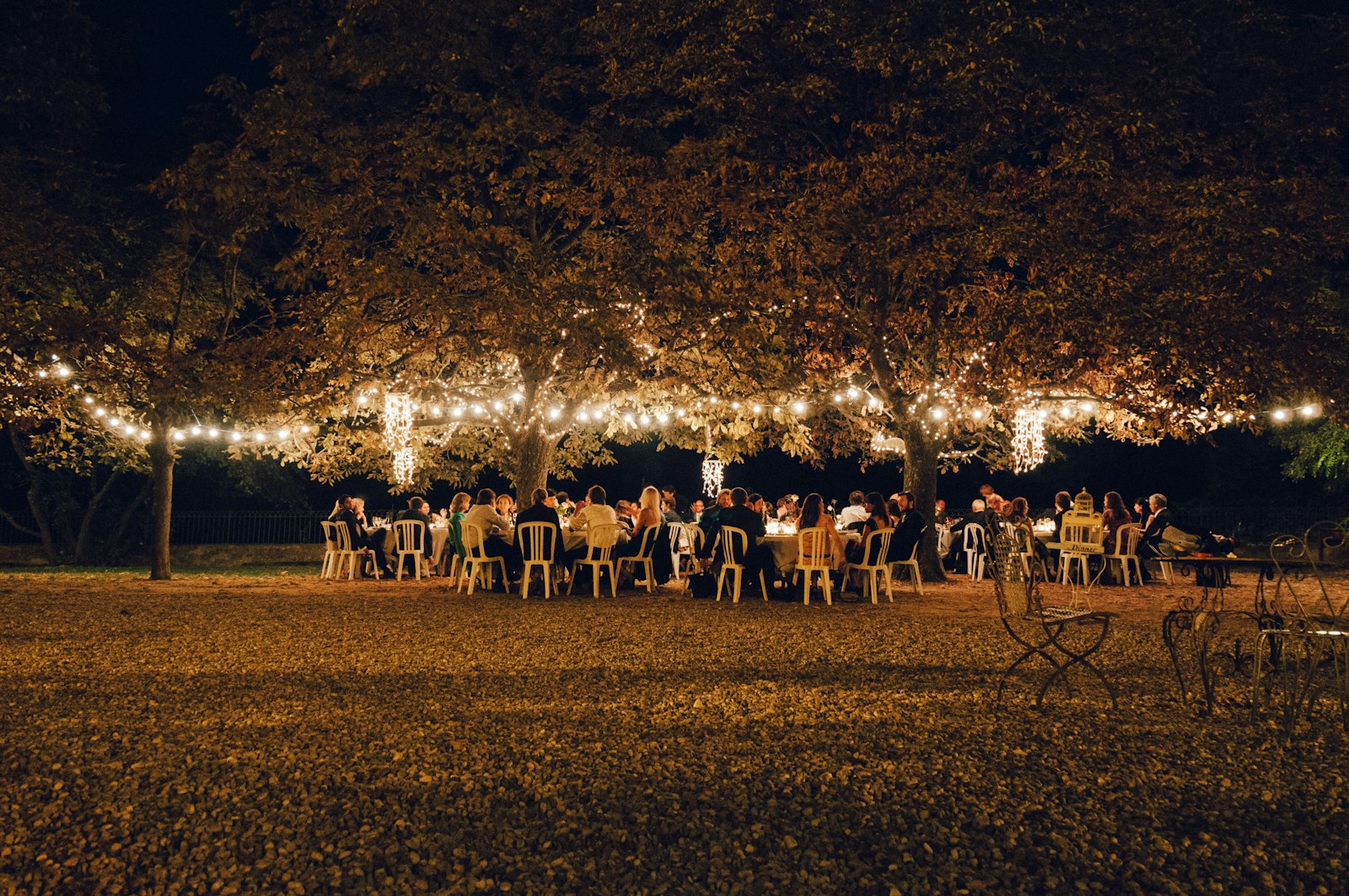 Long tables under string lights at dusk